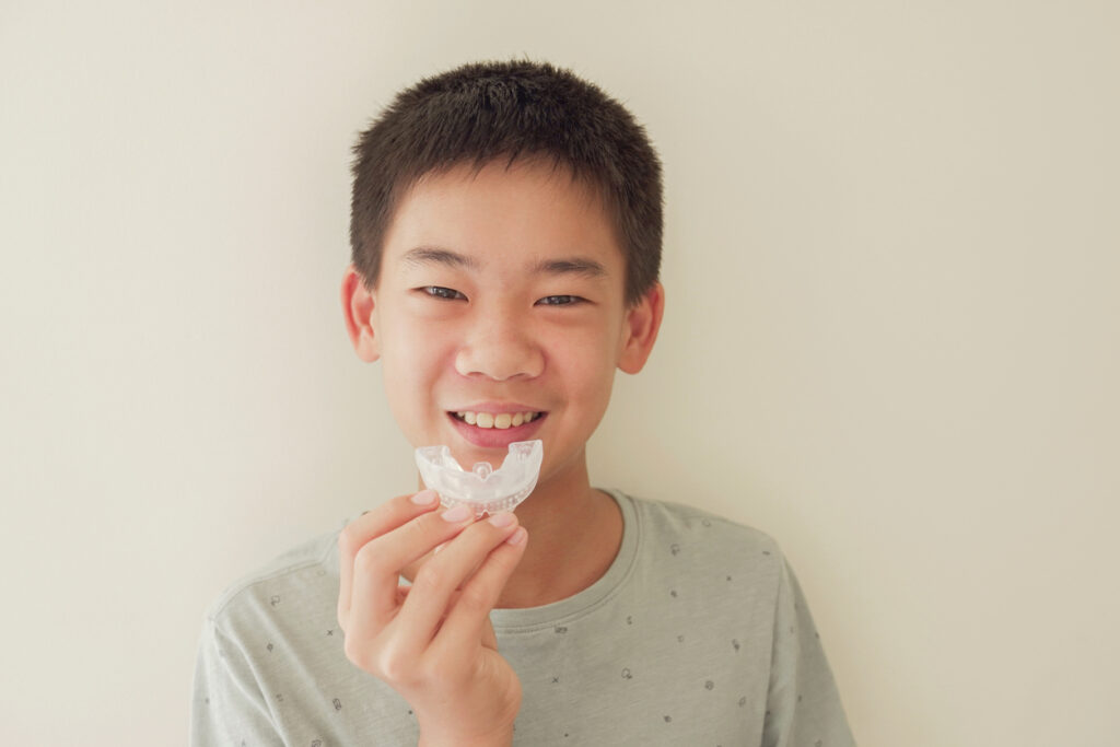 Sports Mouthguards for Kids in Ogden, UT, A kid holding a mouthguard