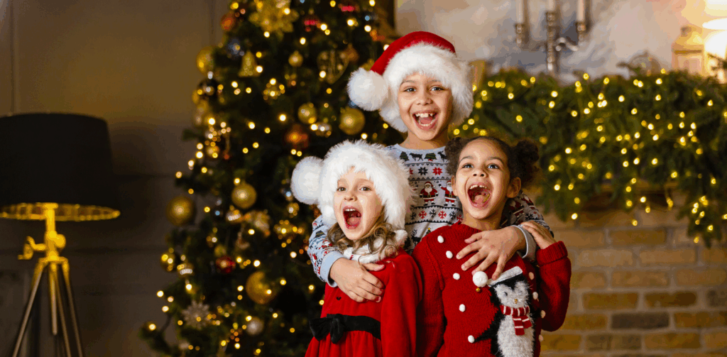 Holiday Dental Tips, three kids laughing in front of a christmas tree