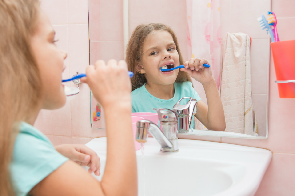 Young child brushing her teeth at home as part of her daily dental care routine.