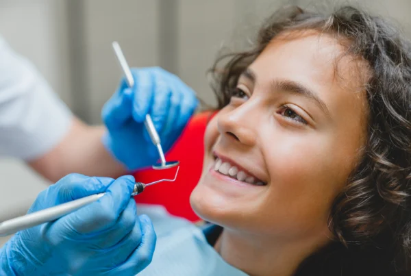 Child smiling during a pediatric dental cleaning and exam.